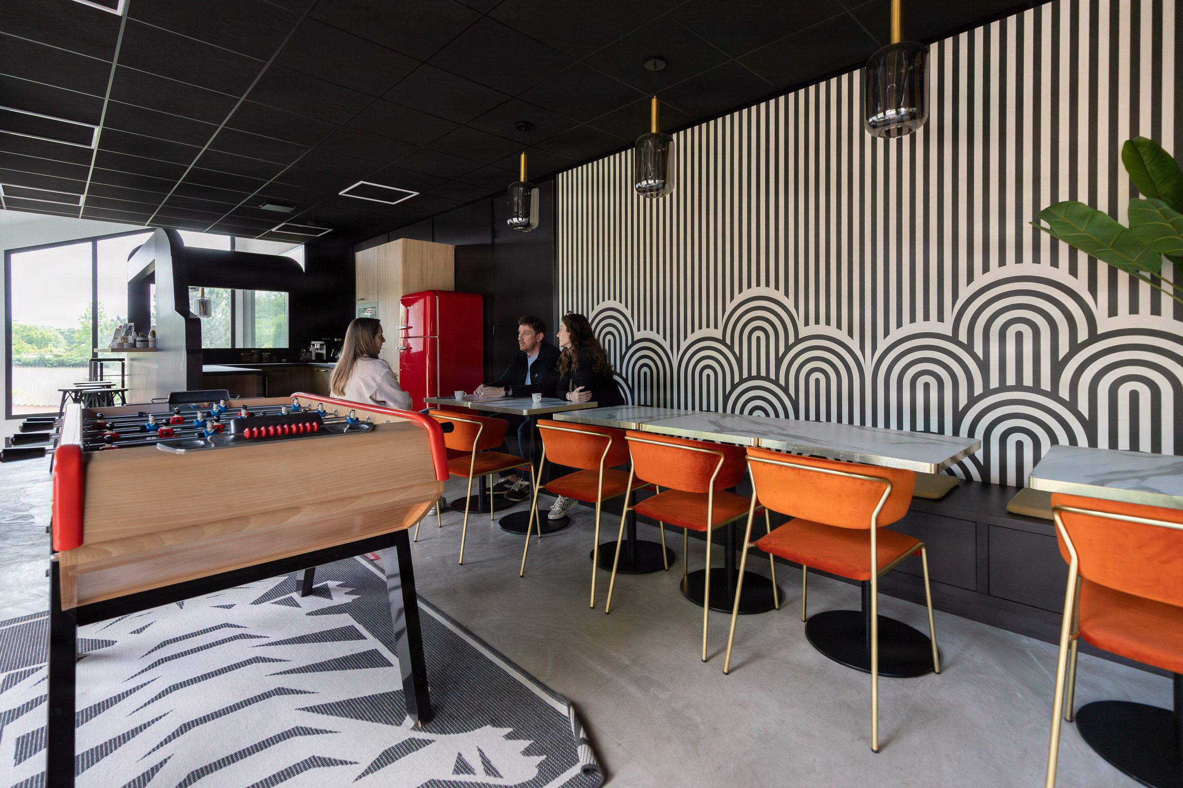 Cafeteria graphique au babyfoot et fauteuils orange